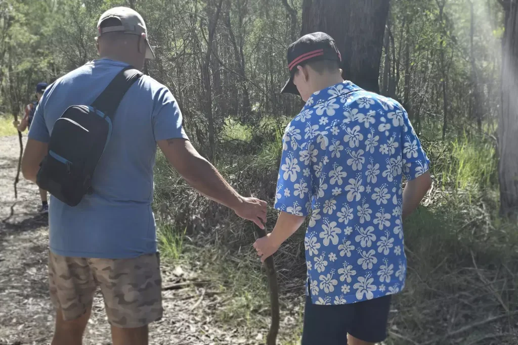 A young participant is on a walk in the forest with his care provider