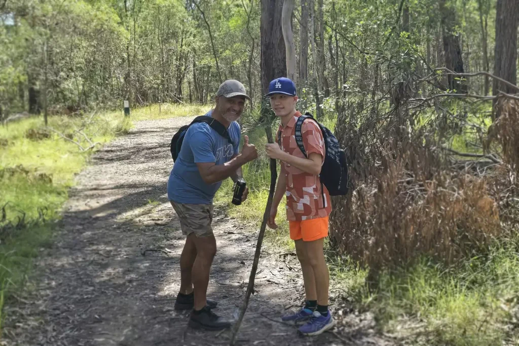 A young participant is on a walk in the forest with his care provider