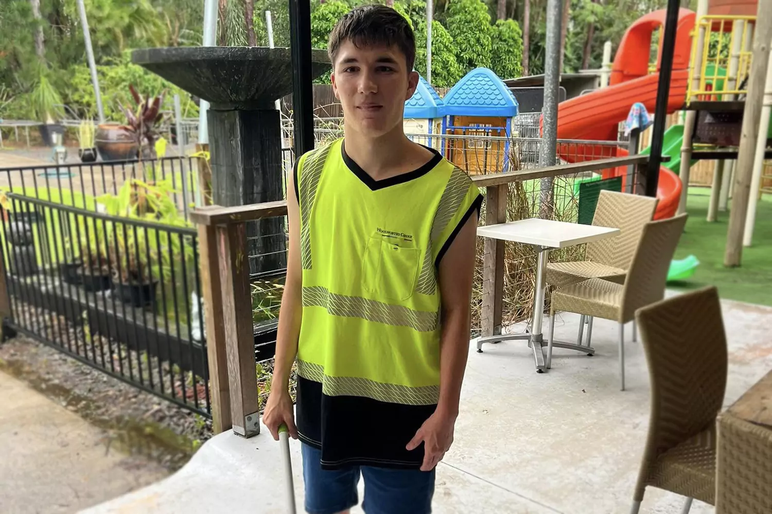 A young man with a disability is enjoying the outdoors while at a park