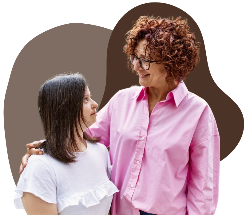 A young woman with down syndrome is smiling with her support provider