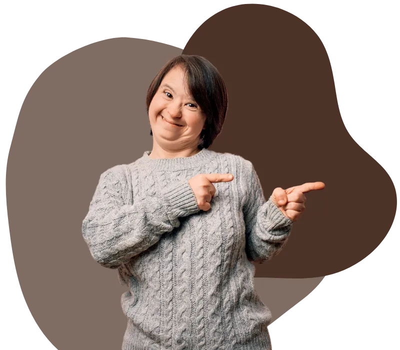 A young woman with down syndrome is smiling while pointing to her left